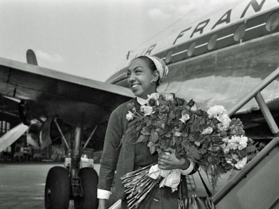 Josephine Baker stands in front of airplane in Berlin, 14 May 1955