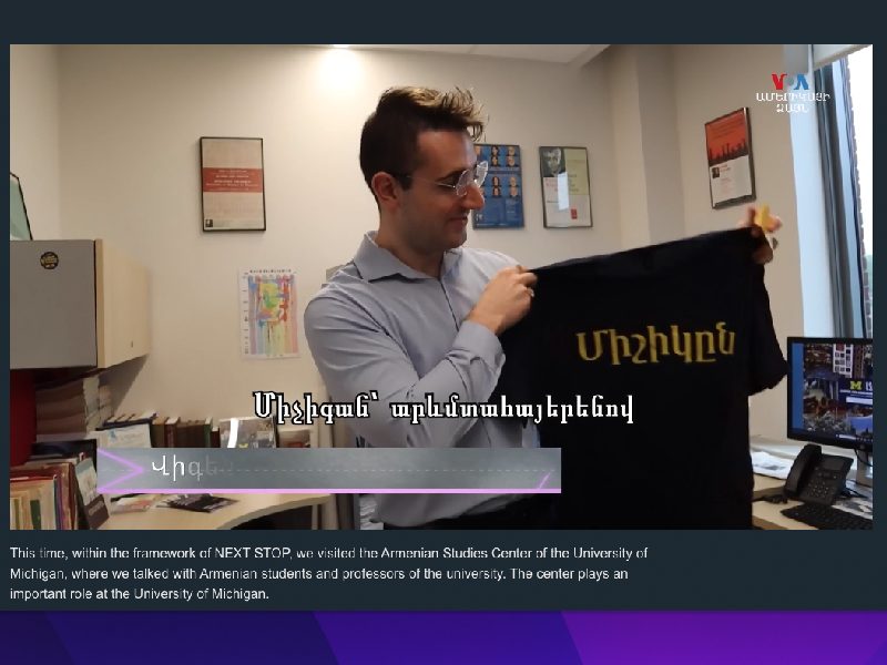 clip from the Voice of America video; Vicekn Moroudian holding a shirt with Michigan in Armenian script.