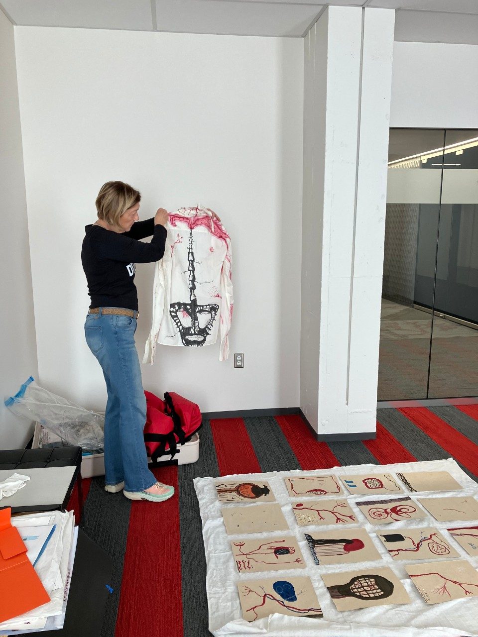 Curator Dianne Beal hanging a textile piece.