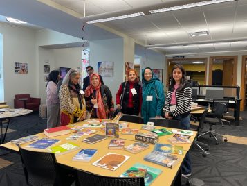 Group of people standing around a table looking at miscellaneous documents