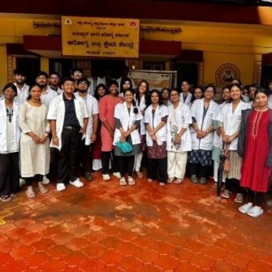 A large group of medical professional are standing in a row posing for the camera with smiles