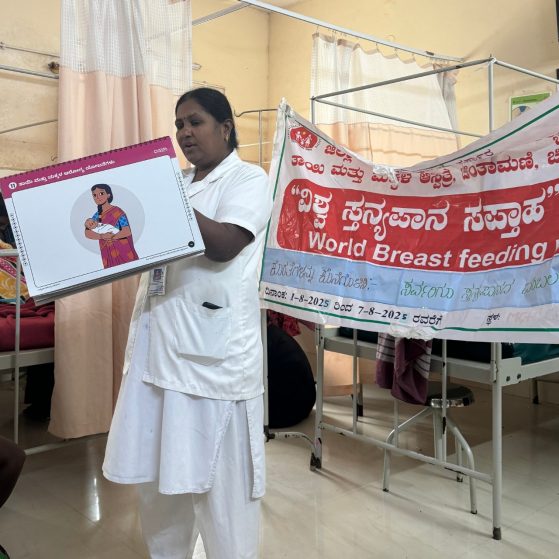 A nurse is doing a presentation in front of a sign that says "Word Breastfeeding"