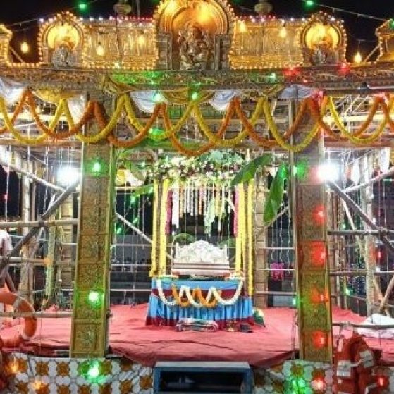 A colorful stage lit up in multicolored lights with gold Indian relics displayed prominently