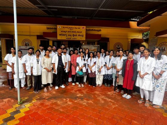 A large group of medical professional are standing in a row posing for the camera with smiles