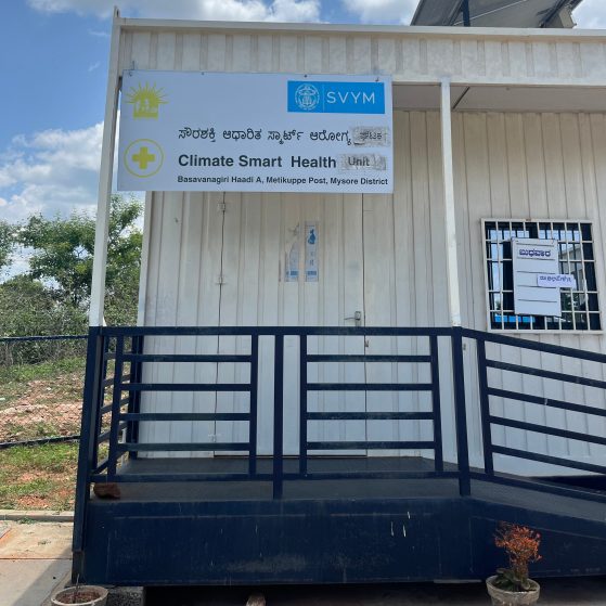 A white trailer with an accessibility ramp and sign on the front that says "Climate Smart Health"