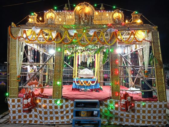 A colorful stage lit up in multicolored lights with gold Indian relics displayed prominently