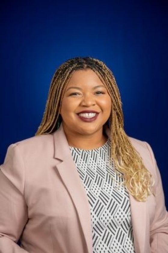 Apryl Williams Headshot, professional cloths and solid color background
