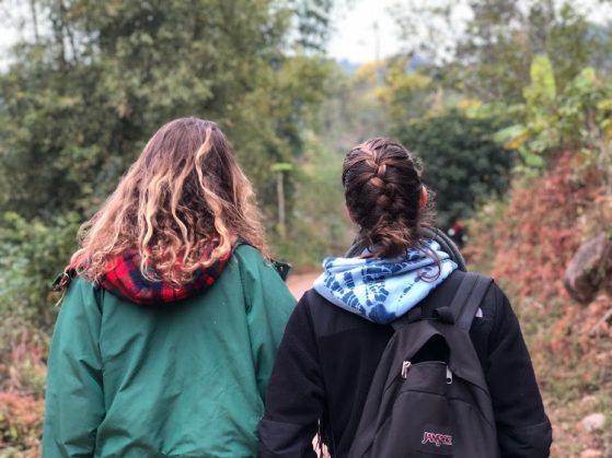 Photo of two young women walking along a path.