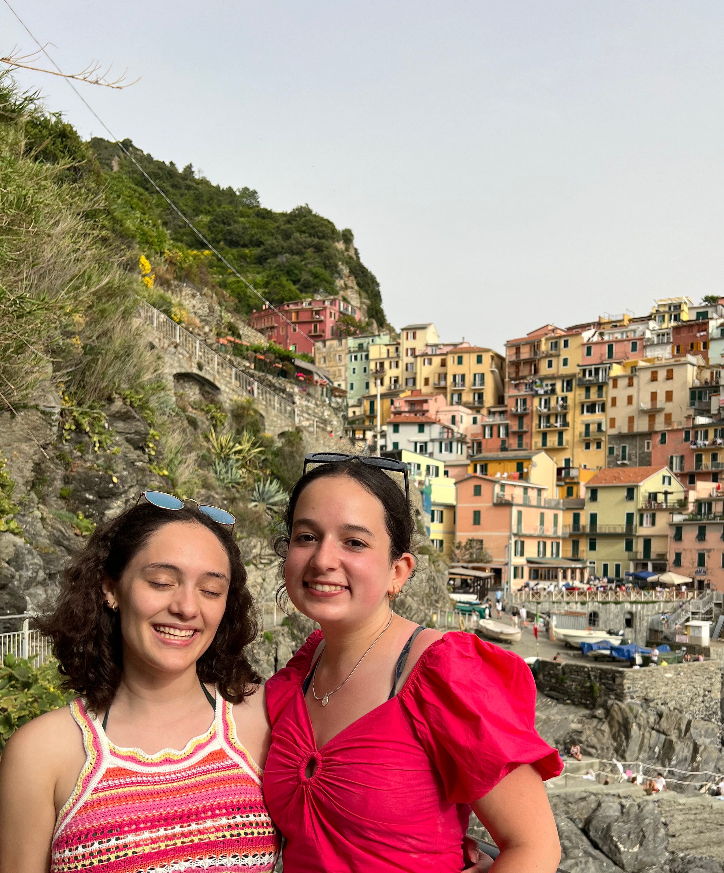Julia and a classmate posing in front of colorful buildings