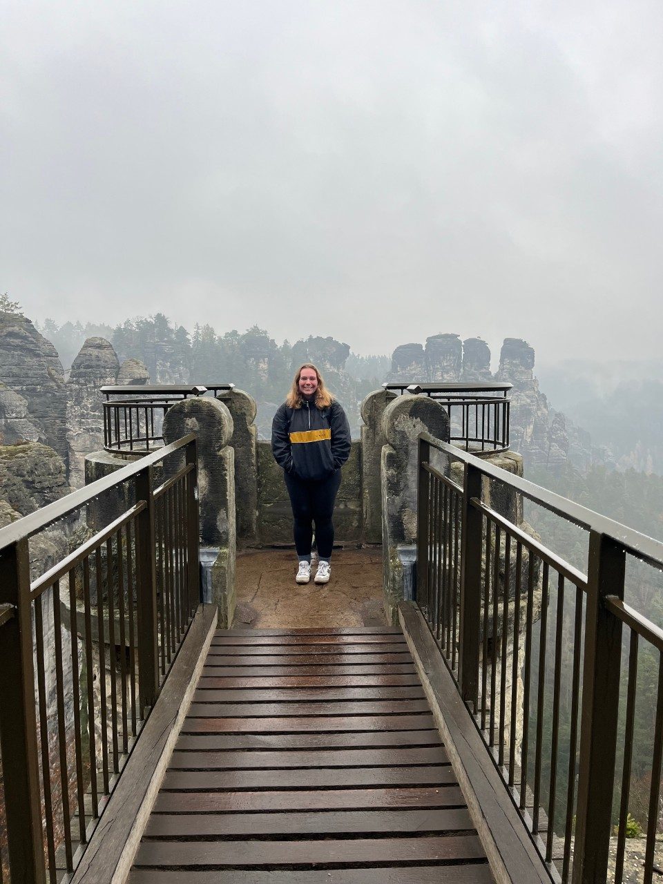 Nadia stands for a photo at an scenic overlook.