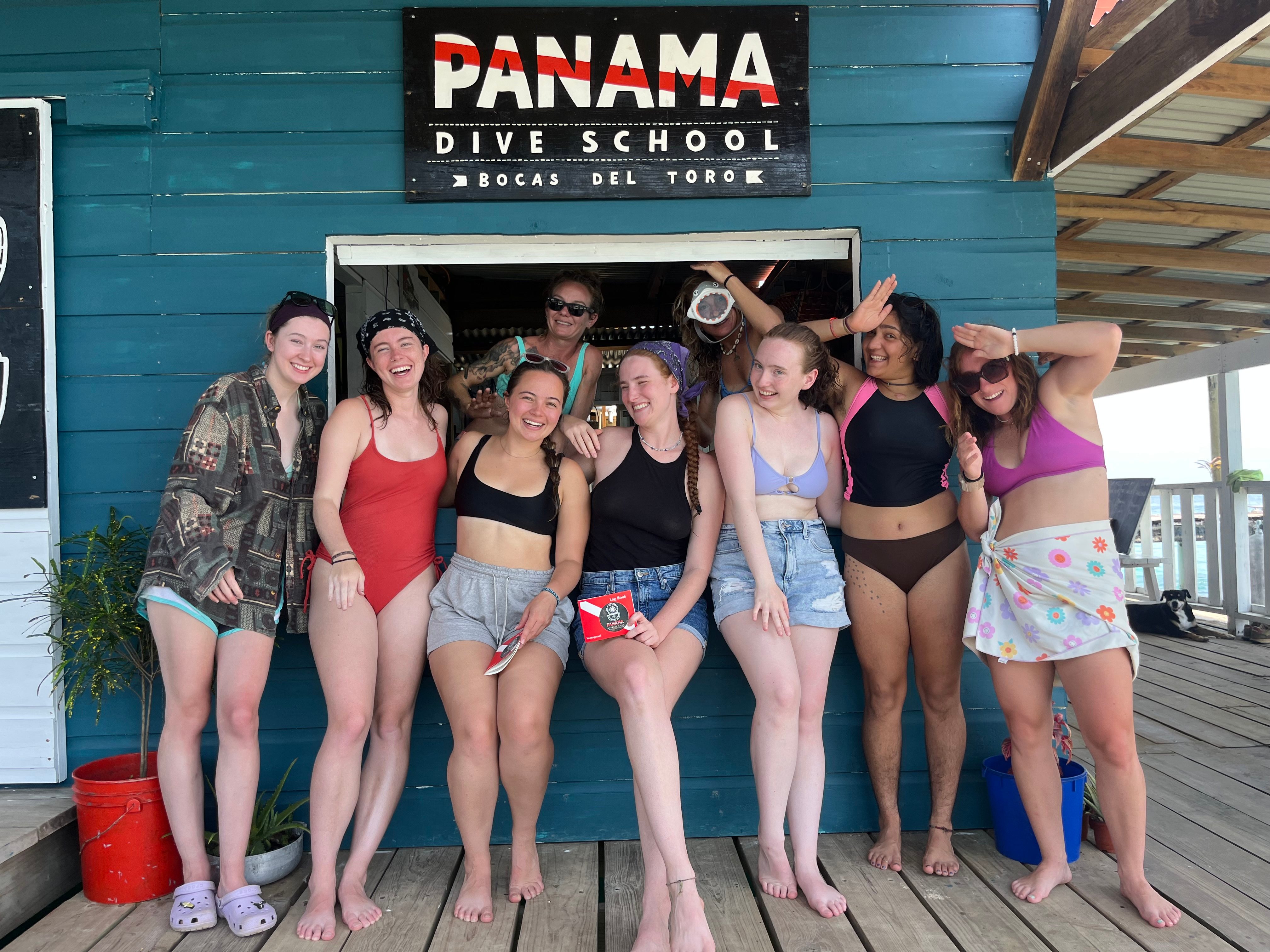 Students in program posing in front of a Panama scuba diving sign