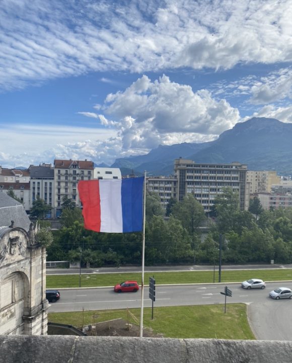 French flag in front of city landscape
