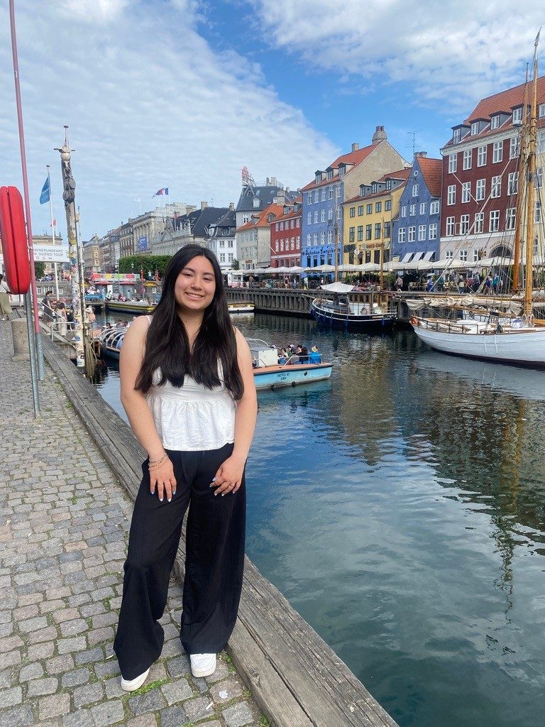 Nicole stands at the canal's edge, with the famous colourful houses of Nyhavn behind her.