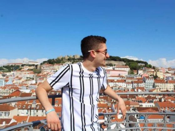 Adam poses on a balcony overlooking the city.