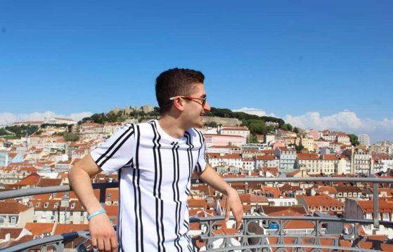 Adam poses on a balcony overlooking the city.