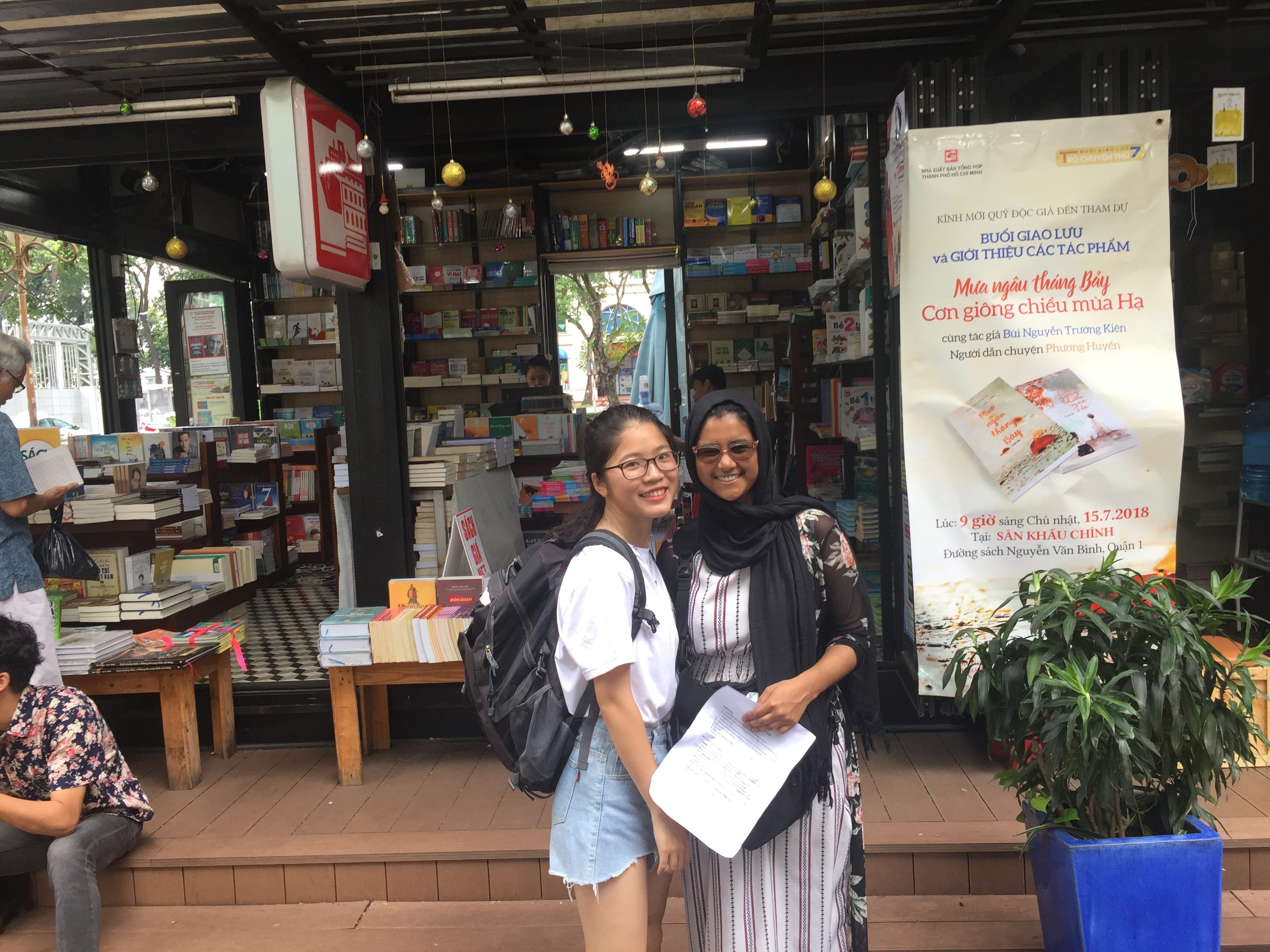 Tazia poses with another student in front of a book shop.