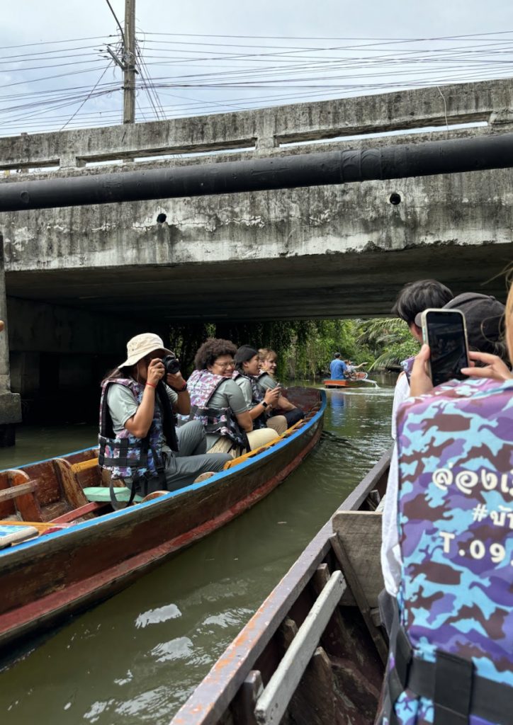 Amari and classmates posing in a small boat
