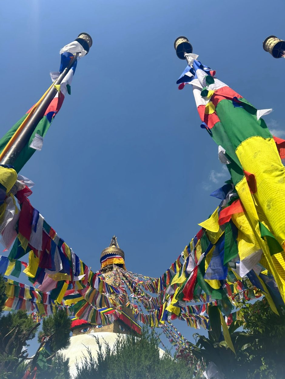 The vibrant colors of the spire of the Stupa and the prayer flags. Prayer flags spread blessings and positive energy through the wind.