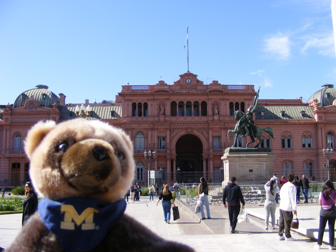 "Selfie" of Wolverine plushie posing in front of Argentinian landmark