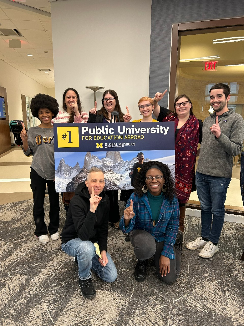 CGIS team members pose with a sign promoting U-M as the #1 public university for study abroad in 2025 within the US