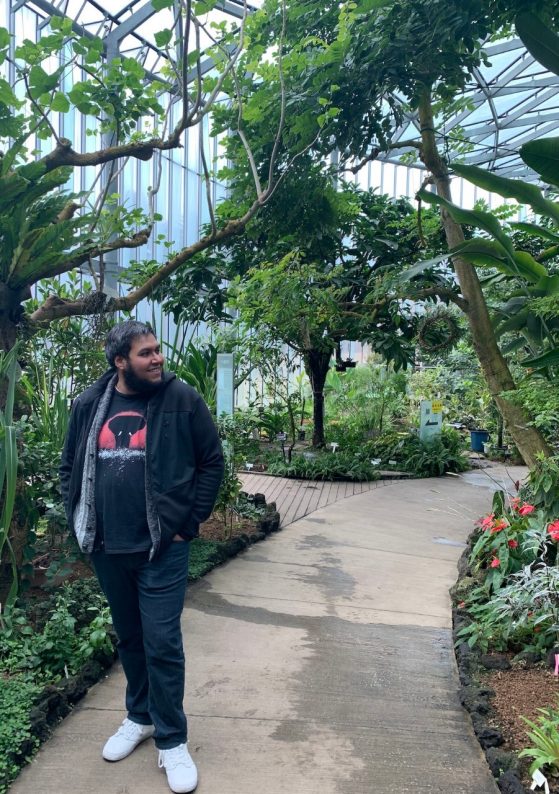Photo of Luis Zaman walking in a greenhouse