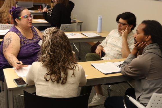 Group of four engaging in dialogue during training