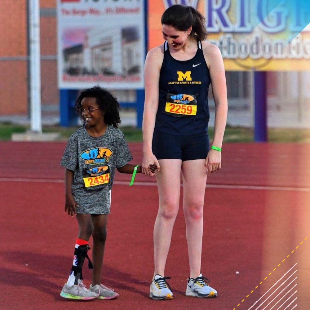 Cathryn Gray holding hands with a little girl athlete