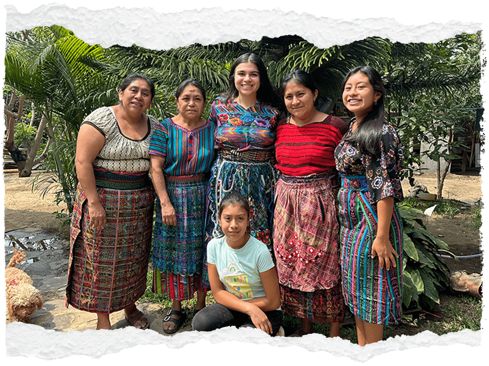 Six people pose for a photo, smiling directly at the camera.