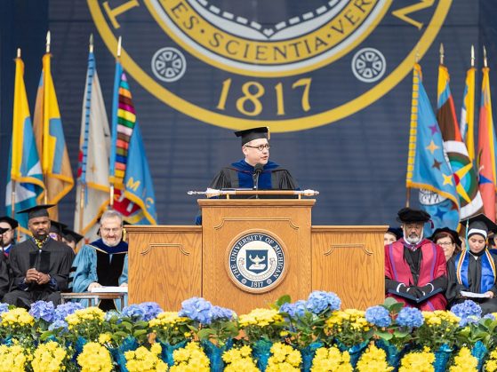 Dean Andrew Martin, in full commencement regalia, stands at the lectern to address the 2018 graduating class.