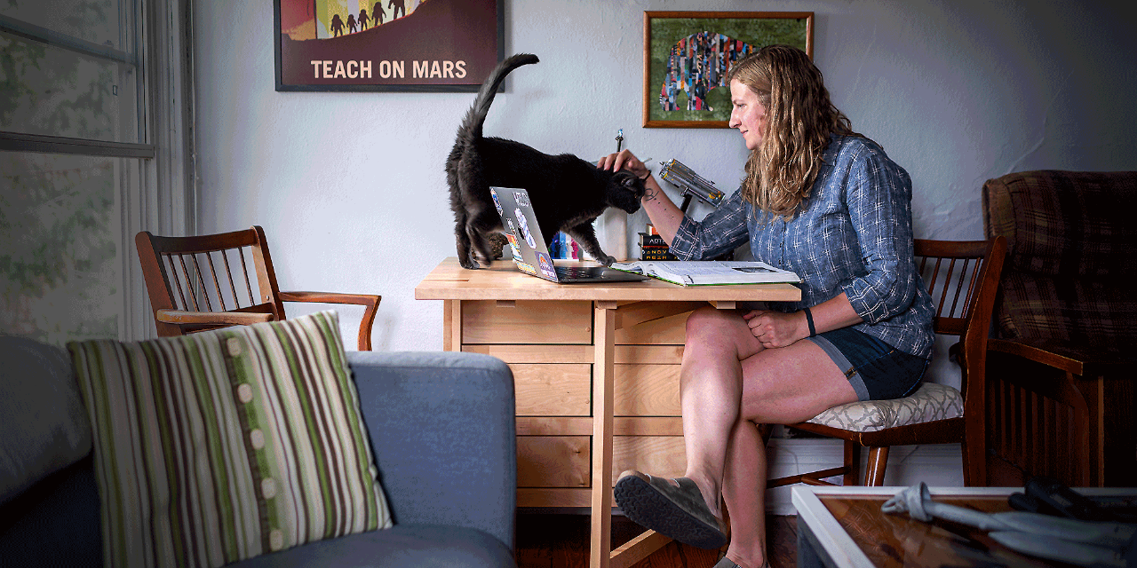 Lydia Pinkham studies at a table in her apartment with her cat Natasha.