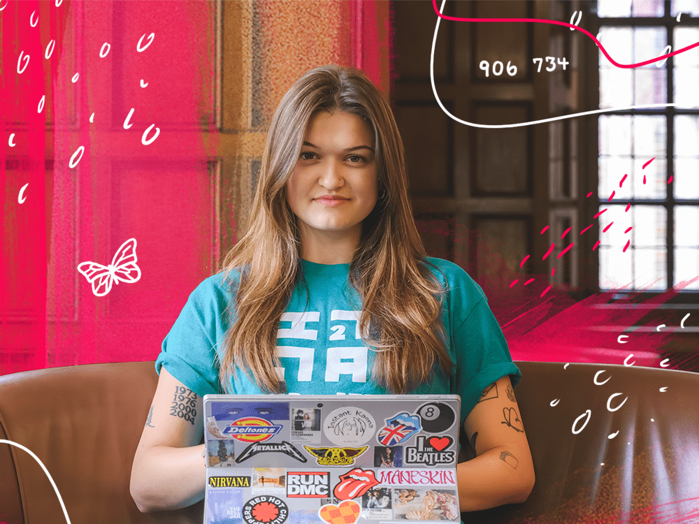 A female college student sits on a couch with her laptop open, with red and white designs drawn around her, including a butterfly.