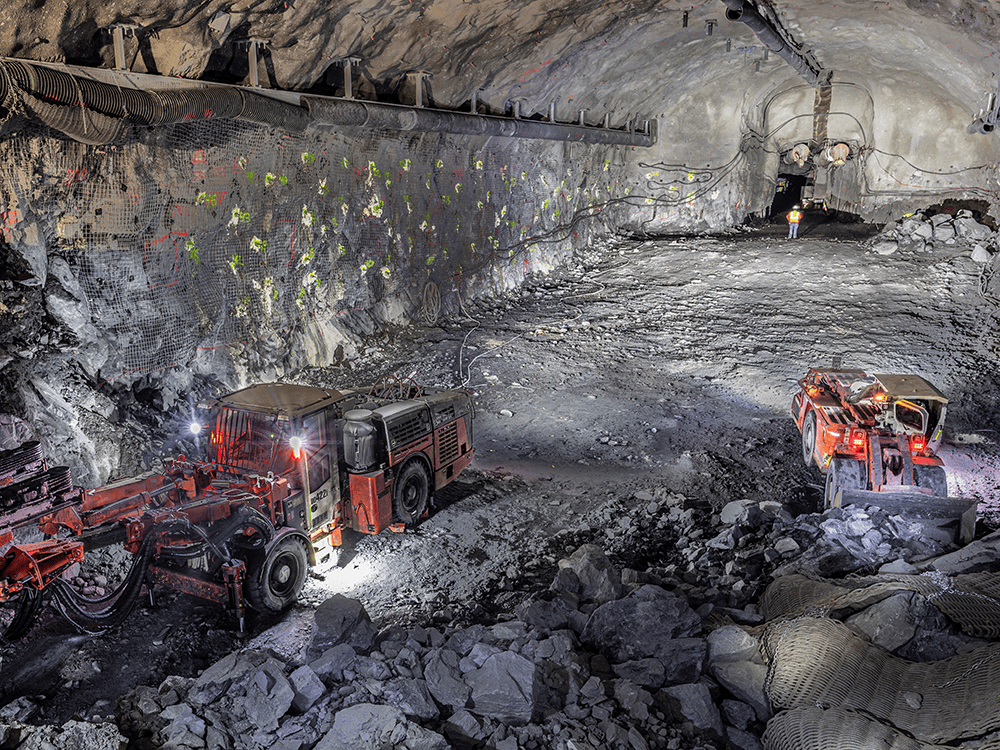 Large excavating equipment is shown in the process of excavating a massive underground space.