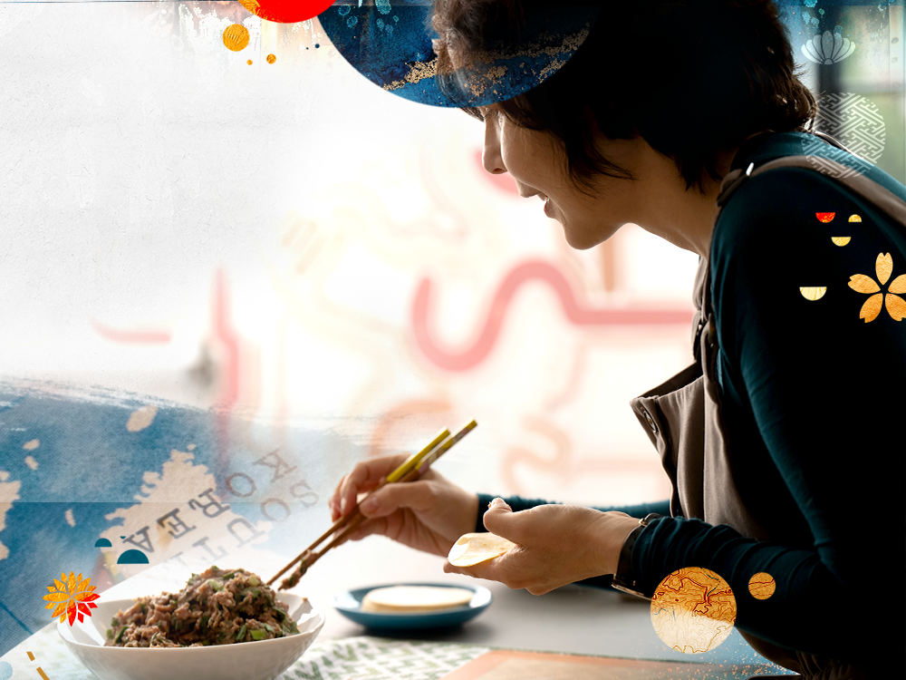 A photograph of Prof. Brown in profile, using chopsticks to fill a dumpling wrapper with lamb.