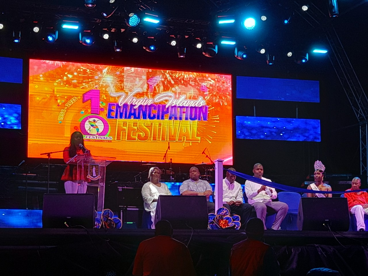 A panel of speakers sit on a stage in front of a screen that reads "Virgin Islands Emancipation Festival"