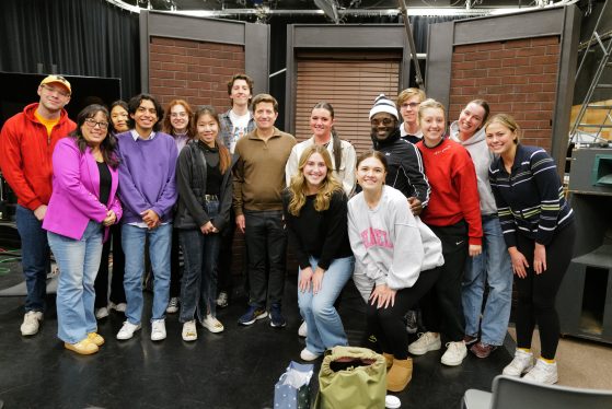 Mark Cendrowski stands with Wolv TV students to pose for a photo