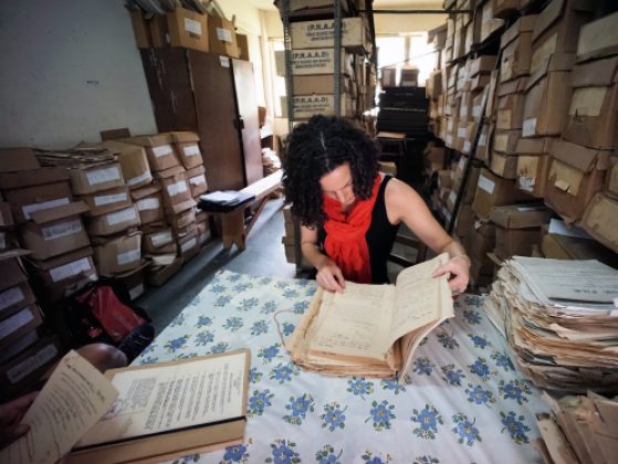 Professor Carina Ray examines an archival document