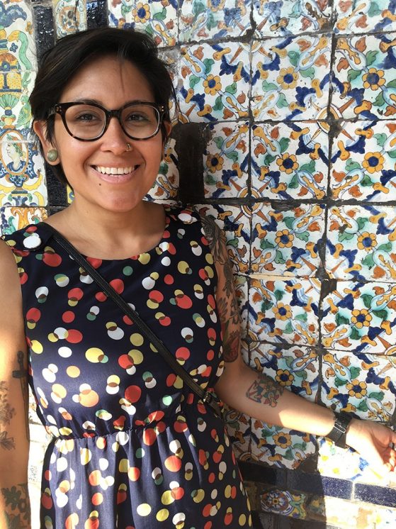 Researcher stands by tile wall in Dominican church in Lima