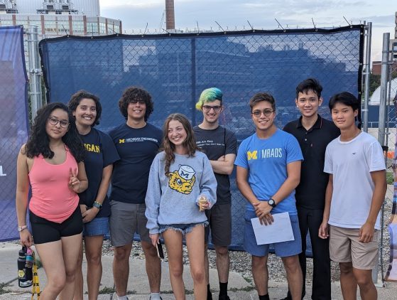 MRADS students engaged in research, standing in front of a fence. 