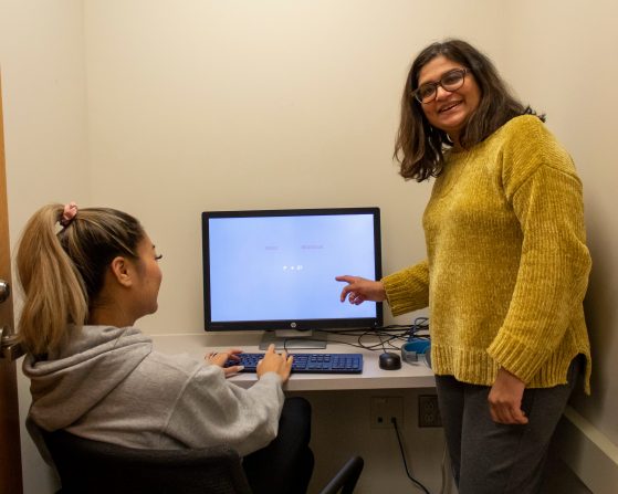 Priti Shah works with undergraduate Quynh Tran testing computerized cognitive tasks.