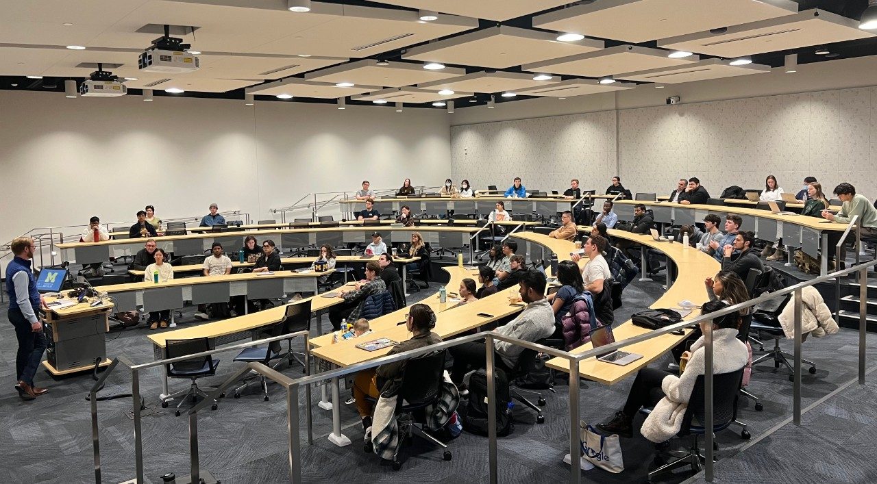 Students sit in a large classroom listening to Mark Stephenson standing at the front of the room