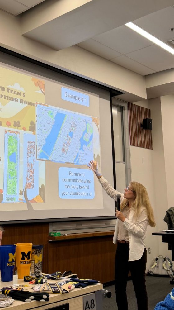 Dr. Whitaker, a QMSS faculty member, shows examples of past VIZ'D submissions for this year's competitors.