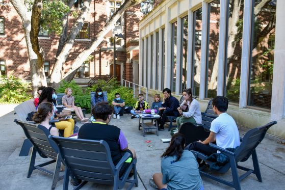 A group of students sitting in a circle together in the East Quad Courtyard