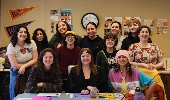 a group of twelve students smile at the camera
