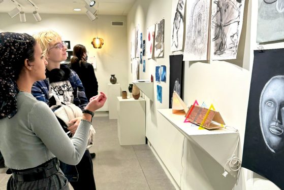 two students consider artwork during the RC Student Art Show Winter 2024