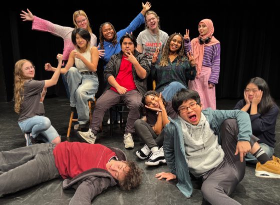 a group of students pose with silly faces on a stage