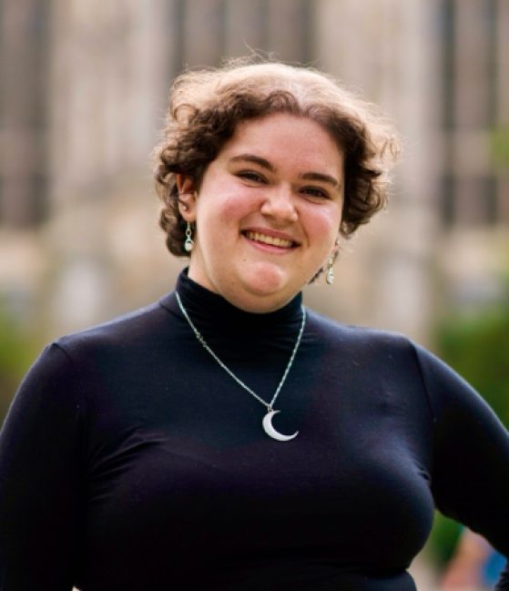 female in black shirt smiling at camera