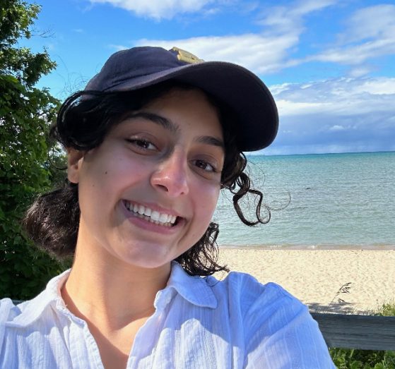 female in white shirt smiling at camera