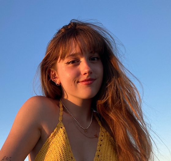 female in yellow top smiling at camera