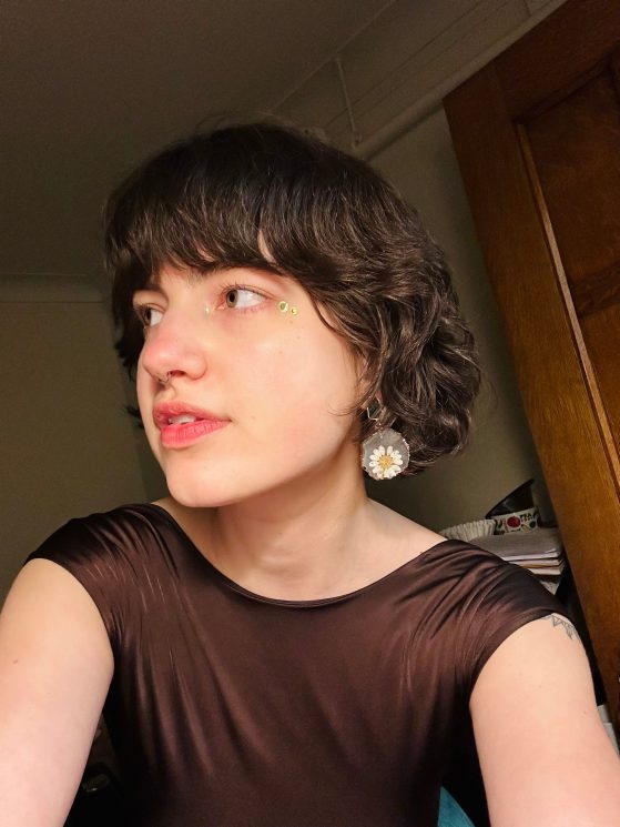 female in black top looking away from camera