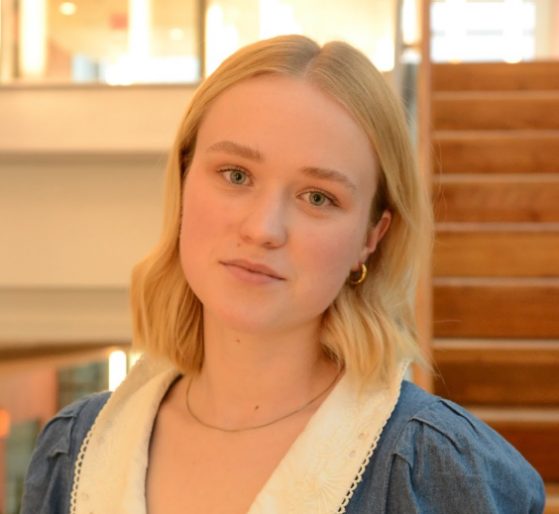 female in blue top smiling at camera